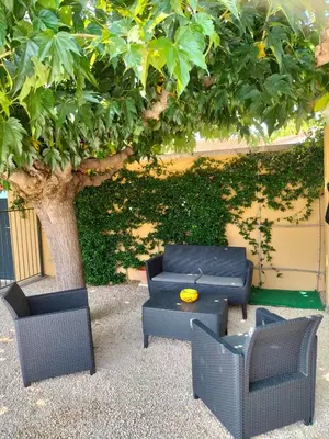 a group of chairs and a table under a tree at Maison Provençale Spa Sauna Piscine in Mollégès
