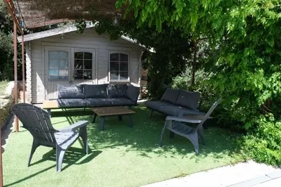 a patio with a couch and a table and chairs at Pleasant part of house with pool to share in Vaucluse, 4/6 people in Puget