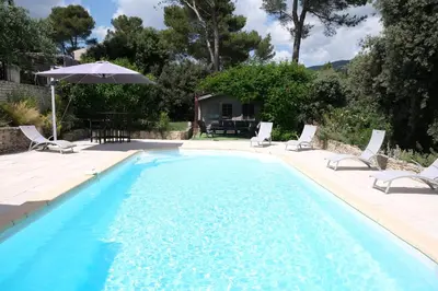 a swimming pool with chairs and an umbrella at Pleasant part of house with pool to share in Vaucluse, 4/6 people in Puget
