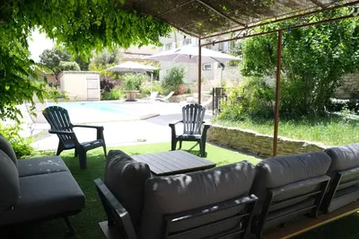 a patio with a couch and two chairs and a pool at Pleasant part of house with pool to share in Vaucluse, 4/6 people in Puget