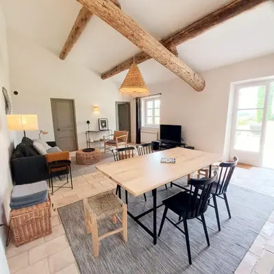 a dining room and living room with a table and chairs at Le Cottage du Chat Blanc in Saint-Didier
