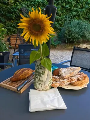 a sunflower in a vase on a table with bread at Maison Lou Roucas in Cabrières-dʼAigues