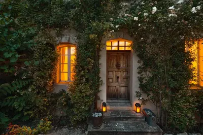 a house with a wooden door and ivy at Maison Lou Roucas in Cabrières-dʼAigues