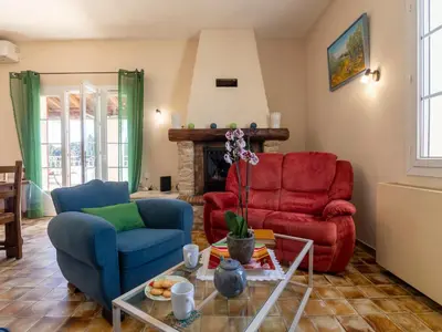 a living room with two chairs and a fireplace at Holiday Home Mas de la Gourmette by Interhome in Châteaurenard