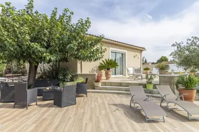a patio with chairs and trees and a house at Villa Mireillo in Noves