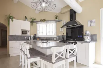 a kitchen with a large kitchen island with white cabinets at Villa Mireillo in Noves