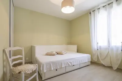 a bedroom with a bed and a chair and a window at Villa Mireillo in Noves