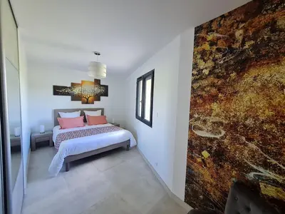 a bedroom with a bed with pink pillows at Mas Des Fugueyrolles in Cavaillon