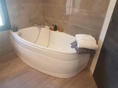 a white bath tub in a bathroom with towels at Mas Des Fugueyrolles in Cavaillon