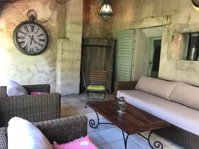 a living room with a couch and a clock on the wall at Bastide La Destinée in Ménerbes