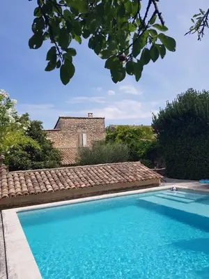 a swimming pool in front of a house at Bastide La Destinée in Ménerbes