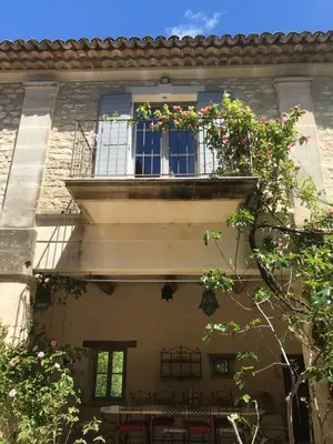 a building with a balcony with a table and chairs at Bastide La Destinée in Ménerbes