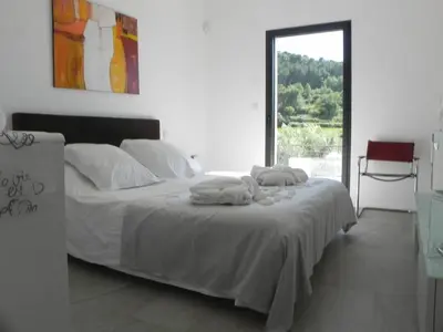 a bedroom with a bed with white sheets and a window at Là Mésange de Venasque in Venasque