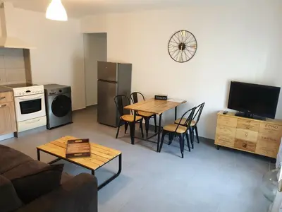 a living room with a table and chairs and a kitchen at Atelier n°4 in Fontaine-de-Vaucluse