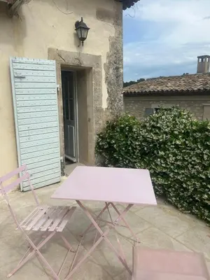a pink picnic table and chair in front of a building at Le mas jasmins in Ménerbes