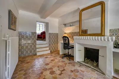 a living room with a fireplace and a mirror at Santonne in Apt