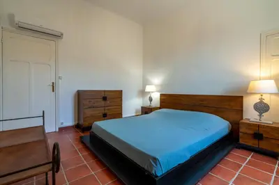 a bedroom with a bed and a table and a chair at Mas Côté Cour in Maubec