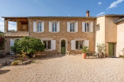 a large house with a courtyard in front of it at Mas Côté Cour in Maubec