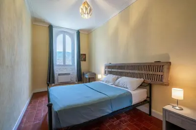 a bedroom with a bed with a large window at Mas Côté Cour in Maubec