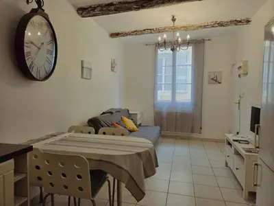 a bedroom with a bed and a clock on the wall at Charmant appartement avec clim - centre historique in Aix-en-Provence
