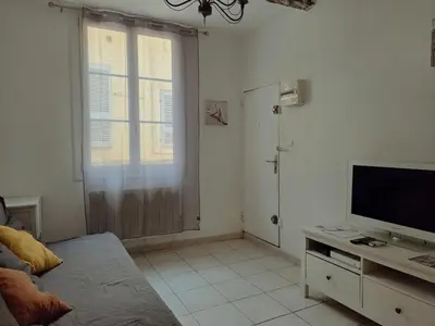 a living room with a television and a couch at Charmant appartement avec clim - centre historique in Aix-en-Provence