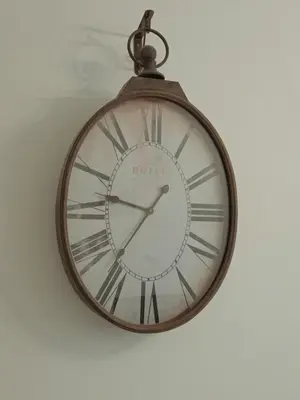 a clock hanging on a wall at Charmant appartement avec clim - centre historique in Aix-en-Provence