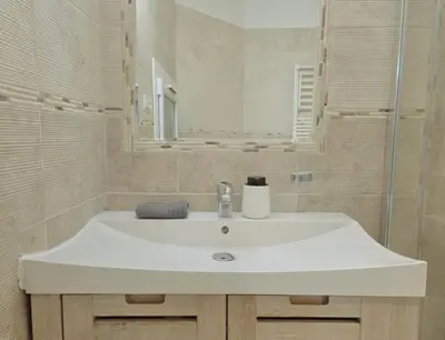 a bathroom with a white sink and a mirror at Charmant appartement avec clim - centre historique in Aix-en-Provence