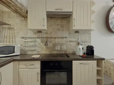 a kitchen with white cabinets and a sink and a microwave at Charmant appartement avec clim - centre historique in Aix-en-Provence