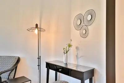 a black table with a vase on it next to a lamp at Quintessence Provence in Goult