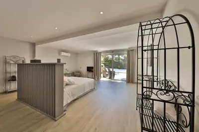 a bedroom with a bed and a iron gate at Quintessence Provence in Goult