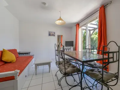 a living room with a table and chairs and a couch at Residence Sun Hols Les Rives du Lac in Saint-Saturnin-lès-Avignon