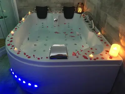a bath tub covered in confetti with candles in it at Esprit Zen en Provence Studio Spa privatif in Cheval-Blanc