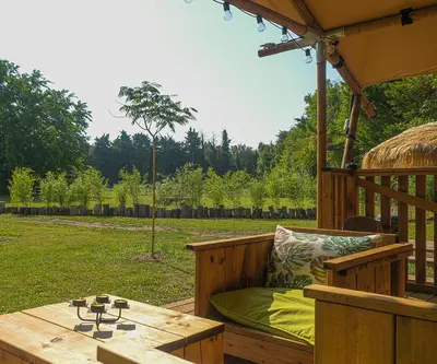 a wooden deck with a bench and a table at Lodge St Exupéry in Le Thor