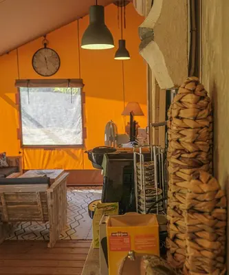 a kitchen with orange walls and a table and a window at Lodge St Exupéry in Le Thor