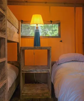 a bedroom with a bed and a lamp on a table at Lodge St Exupéry in Le Thor