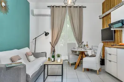 a living room with a white couch and a table at Les Nids de la Diane - Appart'Conforts in Pertuis