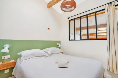 a bedroom with a white bed and a window at Les Nids de la Diane - Appart'Conforts in Pertuis