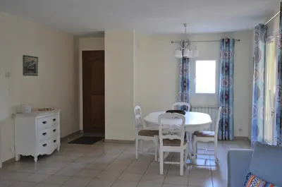 a dining room with a white table and chairs at Gîte de Catherine in Saint-Didier