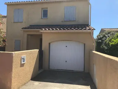 a garage with a white garage door in front of a house at Gîte de Catherine in Saint-Didier