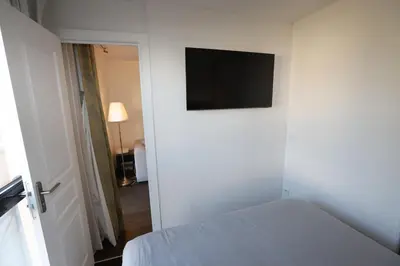 a bedroom with a bed and a flat screen tv on the wall at Floridianes by HRI in Aix-en-Provence