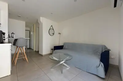 a living room with a blue bed and a table at Provençal Studio Netflix Appart-hotel-Provence in La Fare-les-Oliviers