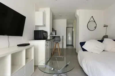 a living room with a couch and a glass table at Provençal Studio Netflix Appart-hotel-Provence in La Fare-les-Oliviers