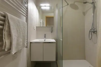 a bathroom with a sink and a glass shower at Provençal Studio Netflix Appart-hotel-Provence in La Fare-les-Oliviers