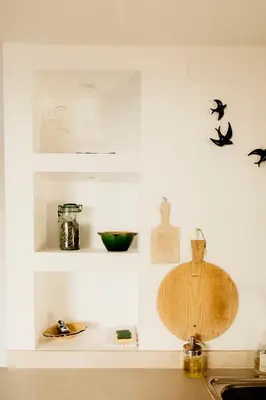 a kitchen with a sink and a counter with birds on the wall at La petite maison in Lourmarin