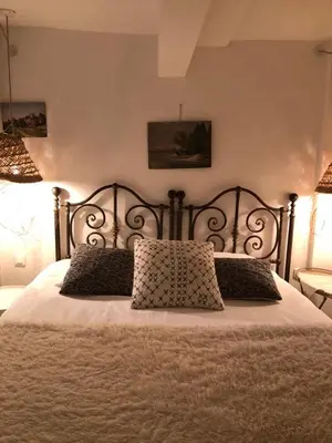 a bedroom with a large bed with two pillows at La petite maison in Lourmarin