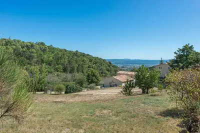 a view of a hill with a house and trees at Mas des Genêts in Manosque