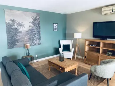 a living room with a couch and a tv at Hôtel le Jas de Joucas in Joucas