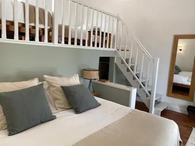 a white bed in a room with a staircase at Hôtel le Jas de Joucas in Joucas