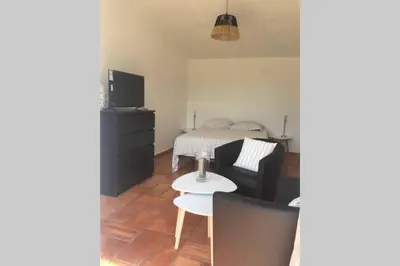 a living room with a bed and a table at Cabanon de charme en plein coeur des vignes in Pertuis