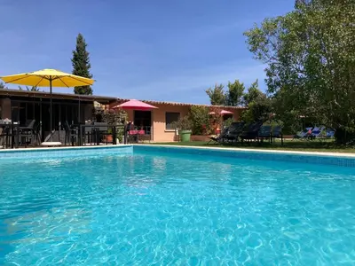 a wooden boat sitting in the grass next to a pool at Mas la Provence in LʼIsle-sur-la-Sorgue